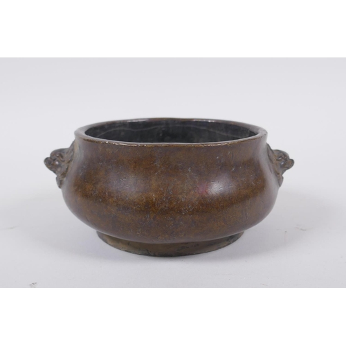 258 - A Chinese bronze censer with Fo dog mask handles, impressed seal mark to base, 12cm diameter