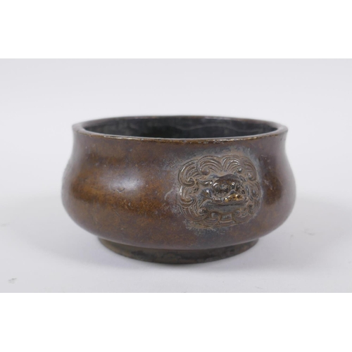 258 - A Chinese bronze censer with Fo dog mask handles, impressed seal mark to base, 12cm diameter