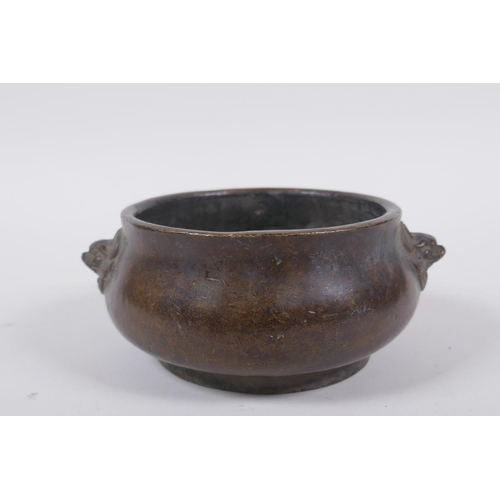 258 - A Chinese bronze censer with Fo dog mask handles, impressed seal mark to base, 12cm diameter