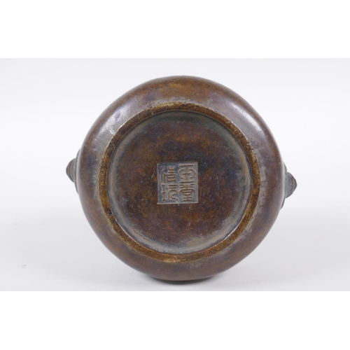 258 - A Chinese bronze censer with Fo dog mask handles, impressed seal mark to base, 12cm diameter