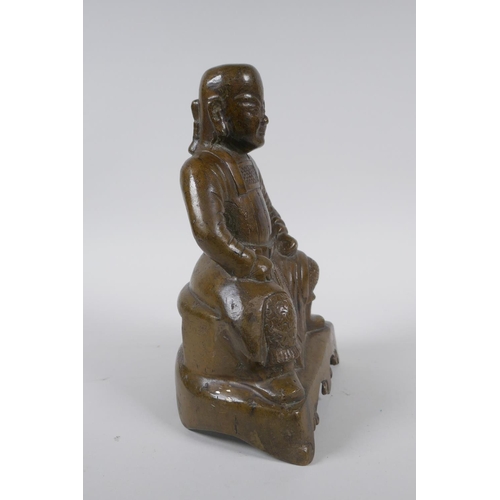 260 - An oriental bronze figure of a seated deity, 21cm high