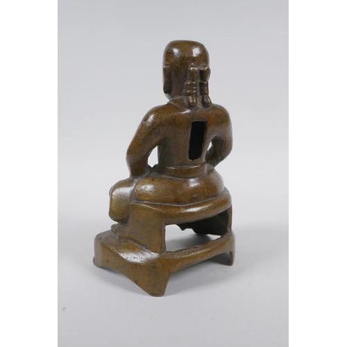 260 - An oriental bronze figure of a seated deity, 21cm high