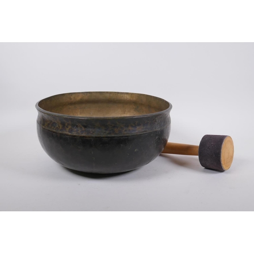 274 - A large Tibetan bronze singing bowl with hammered finish and wood hammer, 13cm high x 28cm diameter