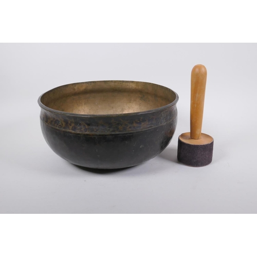 274 - A large Tibetan bronze singing bowl with hammered finish and wood hammer, 13cm high x 28cm diameter