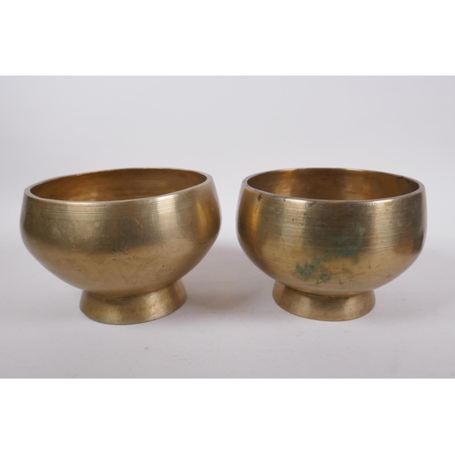 275 - A pair of Tibetan polished bronze footed singing bowls, with wood hammer, 12cm high x 19cm diameter