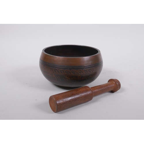 278 - A Tibetan bronze singing bowl with etched decoration and inscriptions, with a wood hammer, 7.5 cm hi... 