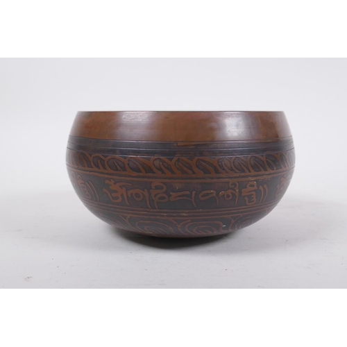 278 - A Tibetan bronze singing bowl with etched decoration and inscriptions, with a wood hammer, 7.5 cm hi... 