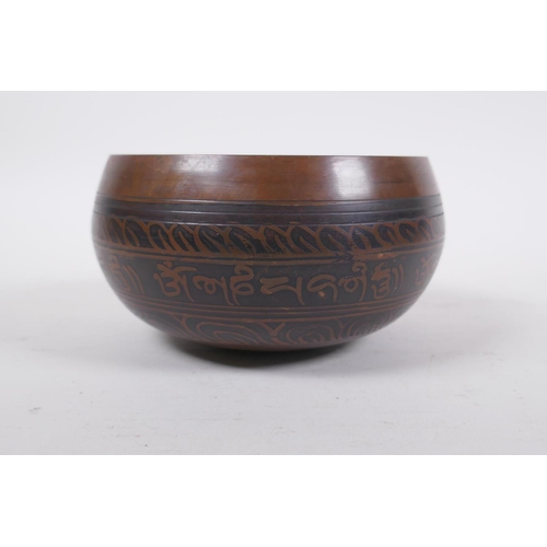 278 - A Tibetan bronze singing bowl with etched decoration and inscriptions, with a wood hammer, 7.5 cm hi... 