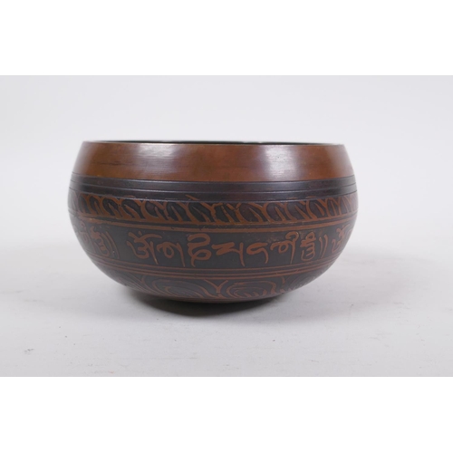 278 - A Tibetan bronze singing bowl with etched decoration and inscriptions, with a wood hammer, 7.5 cm hi... 