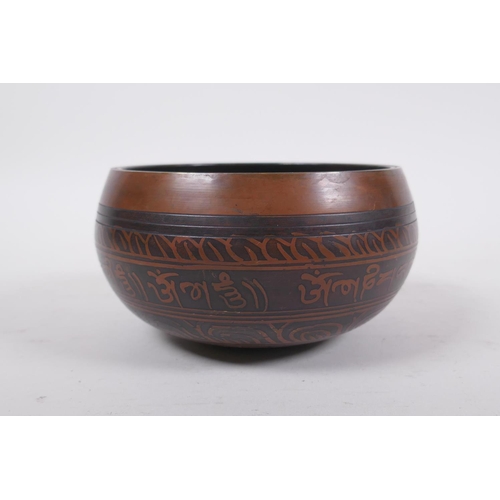 278 - A Tibetan bronze singing bowl with etched decoration and inscriptions, with a wood hammer, 7.5 cm hi... 