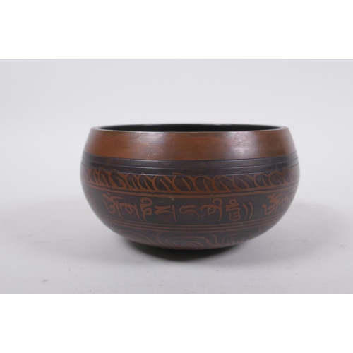 278 - A Tibetan bronze singing bowl with etched decoration and inscriptions, with a wood hammer, 7.5 cm hi... 