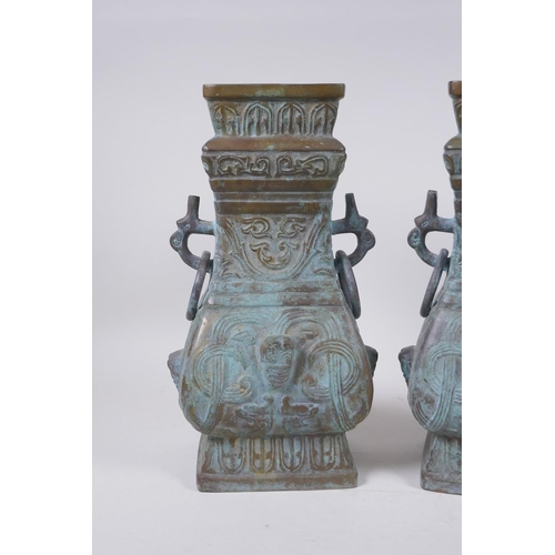 295 - A pair of Chinese archaic style bronze vases with two dragon loop handles, lack bases, 32 cm high