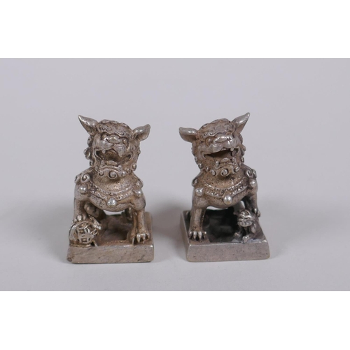 30 - A pair of Chinese white metal seals with Fo dog knops, 3cm high