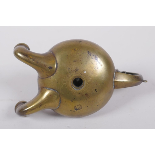 37 - An antique brass twin spout whale oil lamp with animal mask decoration to handle, 15cm long