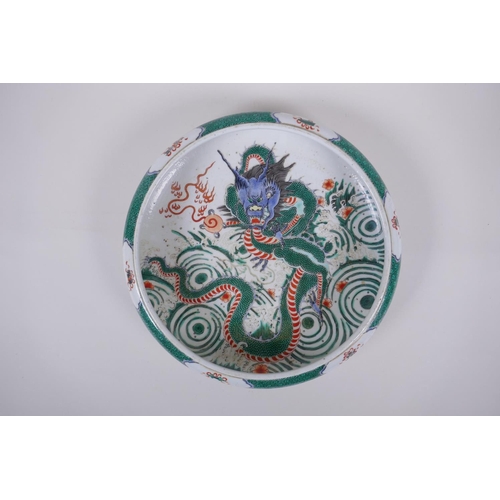 38 - A famille vert porcelain bowl with a rolled rim, decorated with a dragon and flaming pearl, Chinese ... 