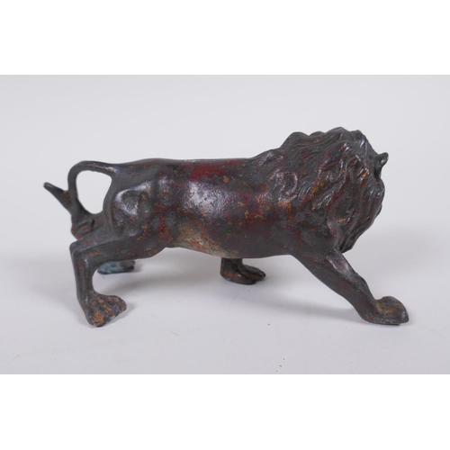 41 - A bronzed and gilt metal lion, 14cm long