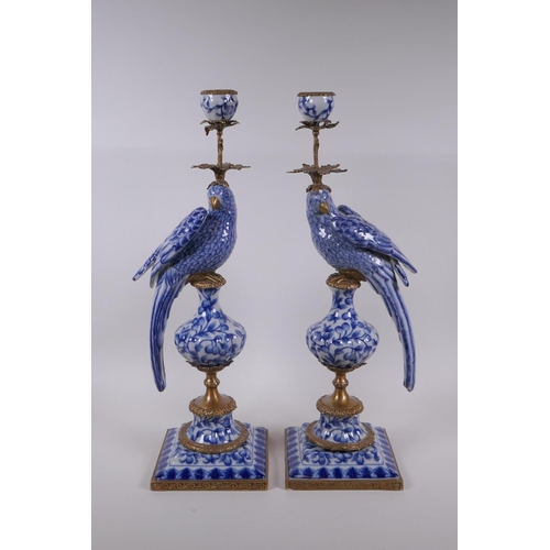 42 - A pair of blue and white porcelain and gilt metal parrot candlesticks, 48cm high