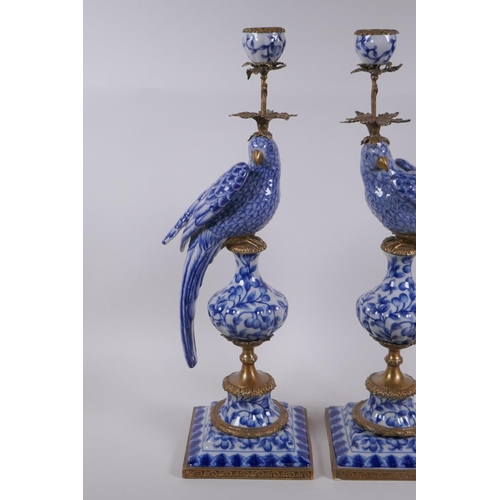 42 - A pair of blue and white porcelain and gilt metal parrot candlesticks, 48cm high