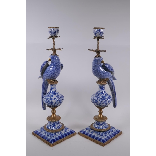 42 - A pair of blue and white porcelain and gilt metal parrot candlesticks, 48cm high