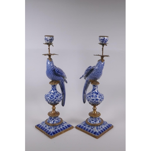 42 - A pair of blue and white porcelain and gilt metal parrot candlesticks, 48cm high