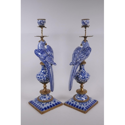 42 - A pair of blue and white porcelain and gilt metal parrot candlesticks, 48cm high