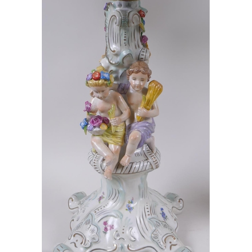 52 - A pair of continental porcelain four branch candelabra decorated with putti, 59cm high