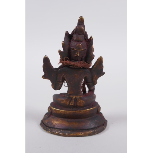 61 - A Tibetan bronze figure of Buddha seated on a lotus throne, 10cm high