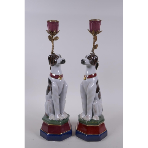 62 - A pair of polychrome porcelain and gilt metal candlesticks in the form of dogs, 34cm high