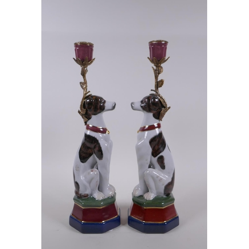 62 - A pair of polychrome porcelain and gilt metal candlesticks in the form of dogs, 34cm high