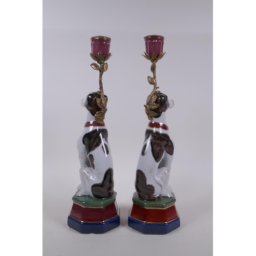 62 - A pair of polychrome porcelain and gilt metal candlesticks in the form of dogs, 34cm high