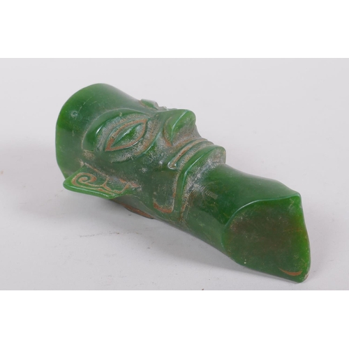 77 - An oriental reconstituted green hardstone archaic style head, 14cm