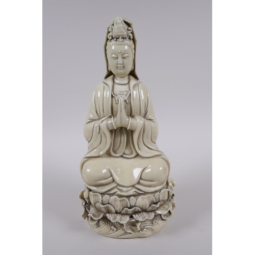 78 - A Chinese blanc de chine porcelain Quan Yin seated on a lotus flower, impressed marks to the reverse... 