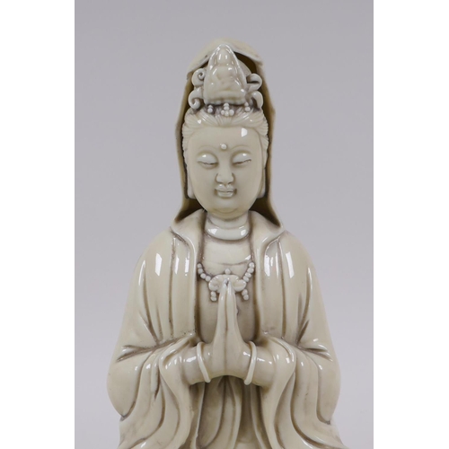 78 - A Chinese blanc de chine porcelain Quan Yin seated on a lotus flower, impressed marks to the reverse... 