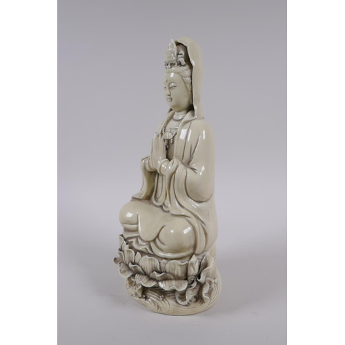 78 - A Chinese blanc de chine porcelain Quan Yin seated on a lotus flower, impressed marks to the reverse... 