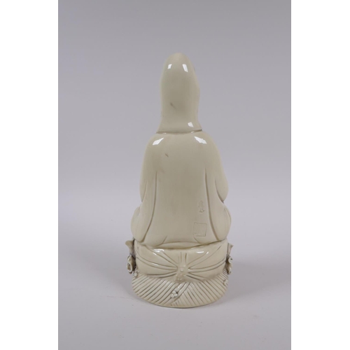 78 - A Chinese blanc de chine porcelain Quan Yin seated on a lotus flower, impressed marks to the reverse... 