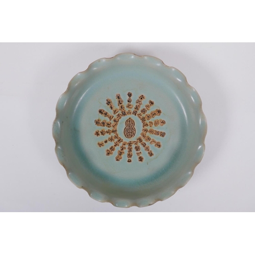 80 - A Chinese celadon glazed porcelain dish with frilled rim and impressed character inscription to the ... 