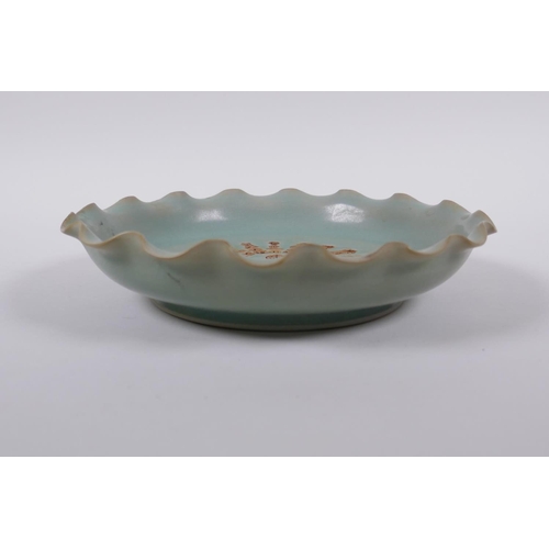 80 - A Chinese celadon glazed porcelain dish with frilled rim and impressed character inscription to the ... 