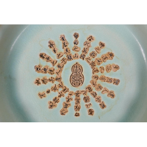 80 - A Chinese celadon glazed porcelain dish with frilled rim and impressed character inscription to the ... 