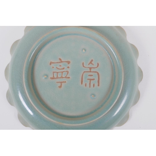 80 - A Chinese celadon glazed porcelain dish with frilled rim and impressed character inscription to the ... 