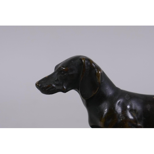 1 - An antique bronze figure of a Dachshund, on a marble base, 10cm long