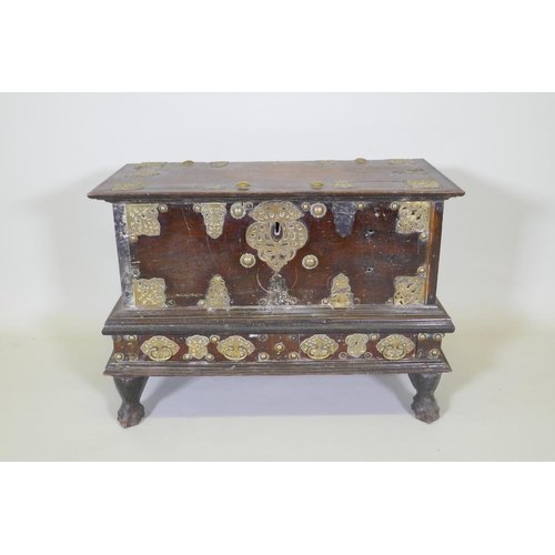 1001 - An C18th Dutch colonial teak chest with brass mounts, lift up top and two drawers, raised on claw fe... 