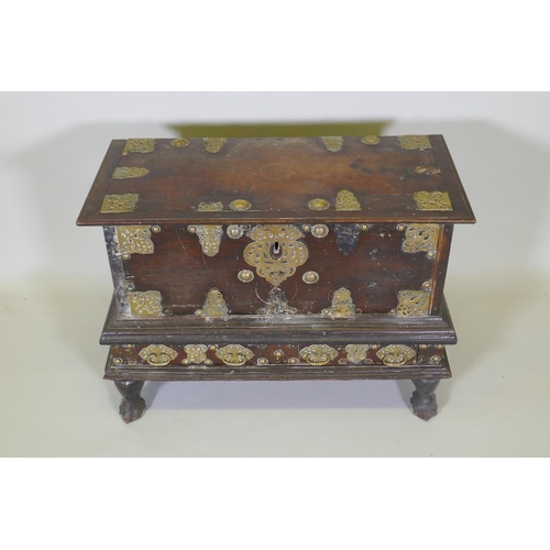 1001 - An C18th Dutch colonial teak chest with brass mounts, lift up top and two drawers, raised on claw fe... 