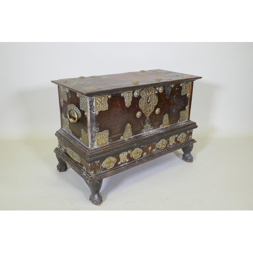 1001 - An C18th Dutch colonial teak chest with brass mounts, lift up top and two drawers, raised on claw fe... 