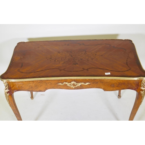 1002 - A French marquetry inlaid bureau plat, with shaped top, single drawer and ormolu mounts, bears label... 