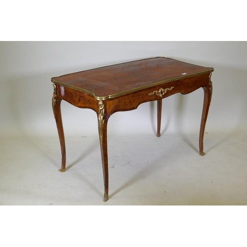 1002 - A French marquetry inlaid bureau plat, with shaped top, single drawer and ormolu mounts, bears label... 