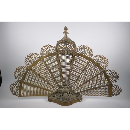 1025 - An antique pierced brass peacock fan fire screen, AF, 60cm high