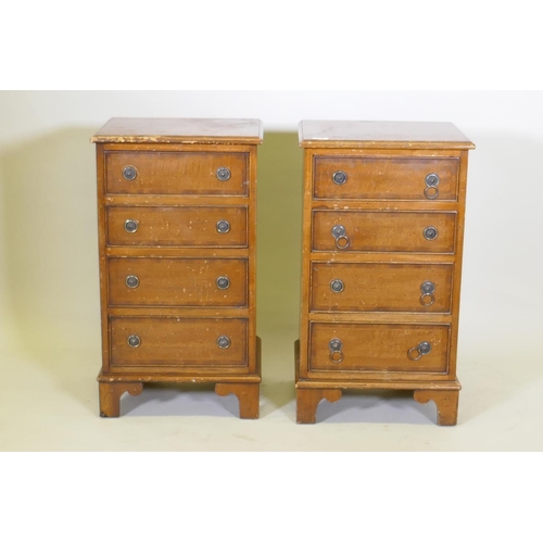 1032 - A pair of mahogany side chests of four graduated drawers with banded inlay, raised on bracket feet, ... 