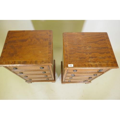 1032 - A pair of mahogany side chests of four graduated drawers with banded inlay, raised on bracket feet, ... 