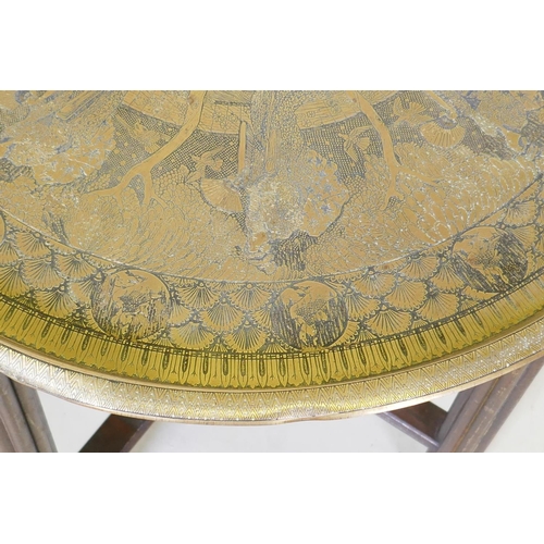 1035 - A Victorian brass top table with Japanese inspired decoration, on a folding wood base, 59 dia. x 55c... 