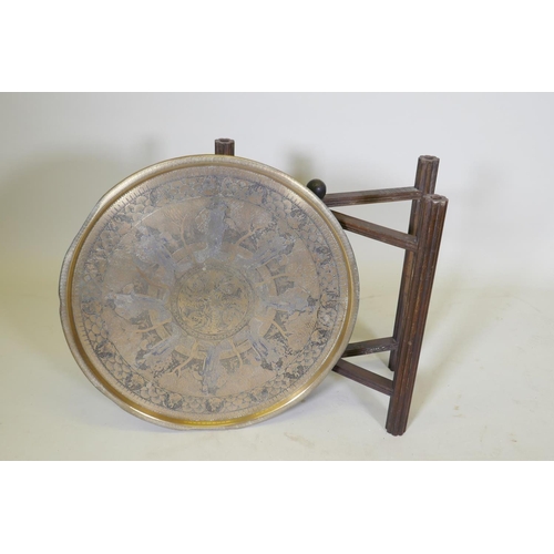 1035 - A Victorian brass top table with Japanese inspired decoration, on a folding wood base, 59 dia. x 55c... 